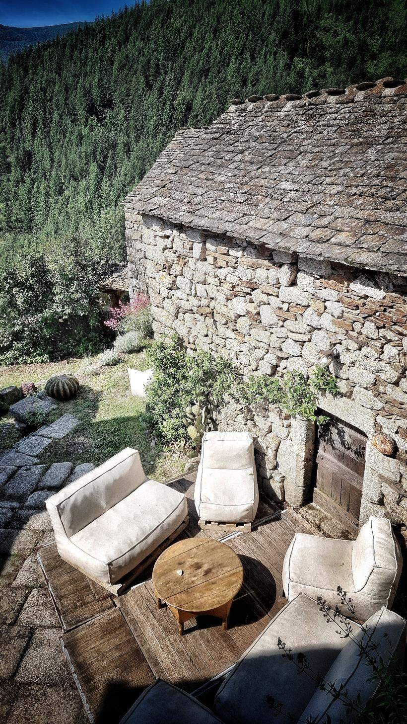 La terrasse en bois et ses fauteuils, ouverte sur la forêt