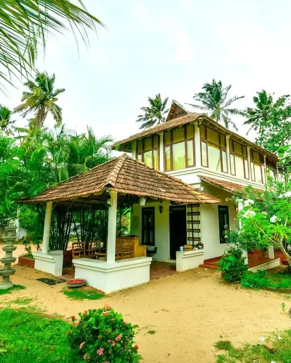 Cottage d'Ayur Beach Resort au toit de tuiles, dans un jardin tropical