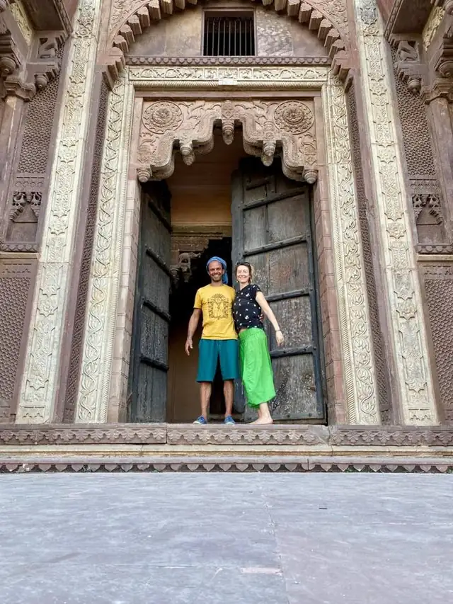 Marie-Laure et Brice dans l'encadrement d'une immense porte de palais sculptée, en Inde
